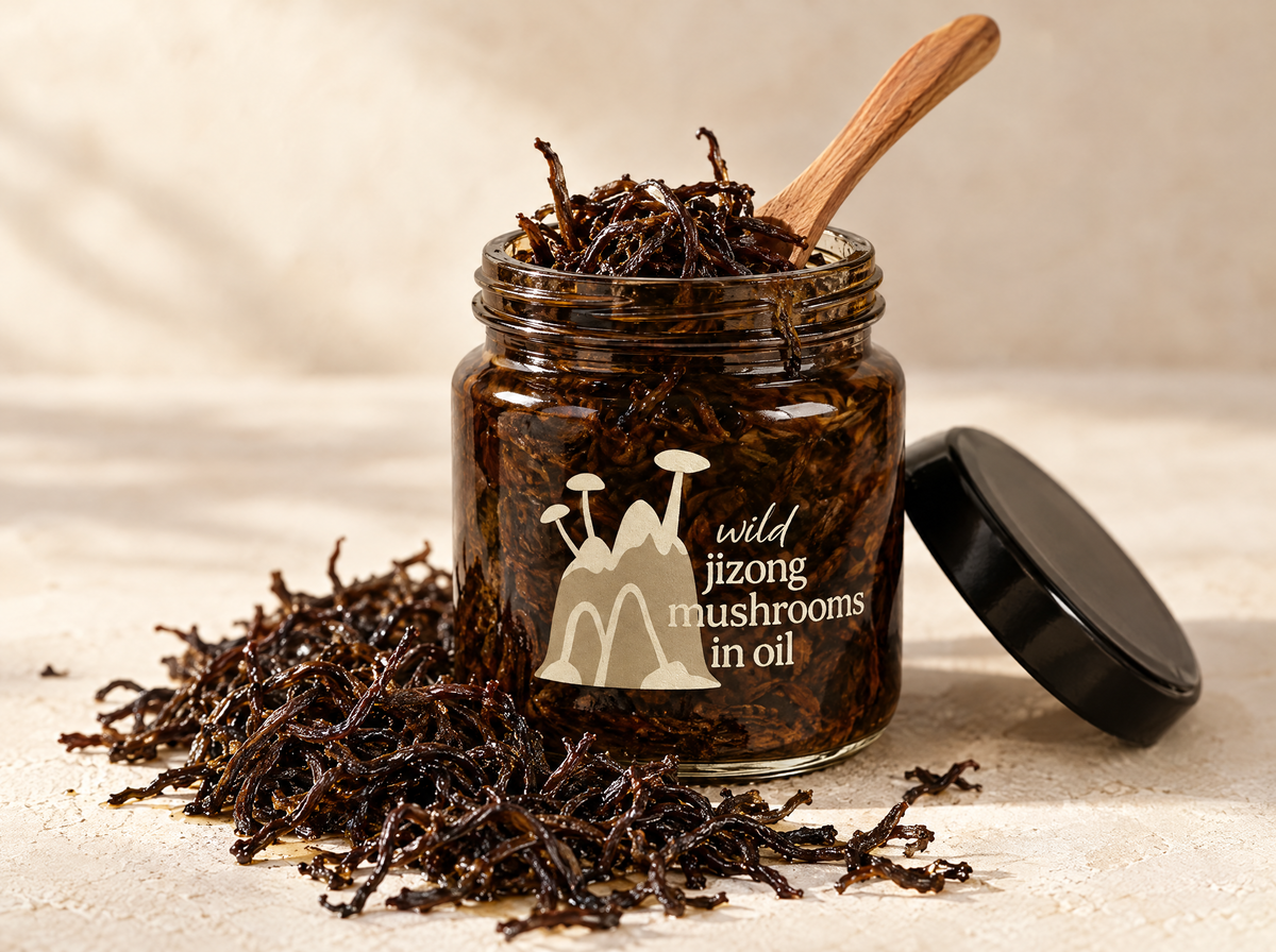 Open jar of Wild Jizong mushrooms in oil with a wooden spoon, dark wiry strands spilled around the base
